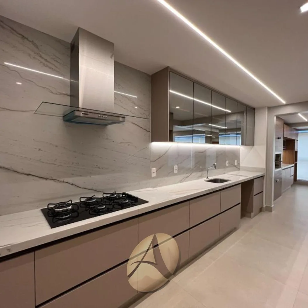 Closet amplo com armários brancos do chão ao teto, puxadores embutidos, banqueta estofada sobre tapete redondo e iluminação em fita LED no teto